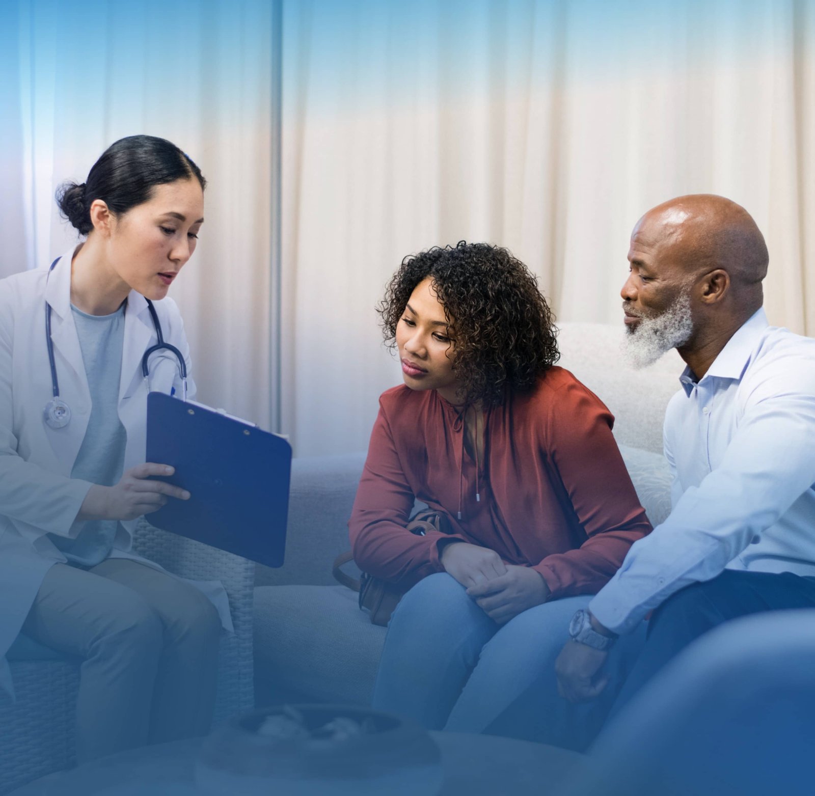 Healthcare professional sitting with two people