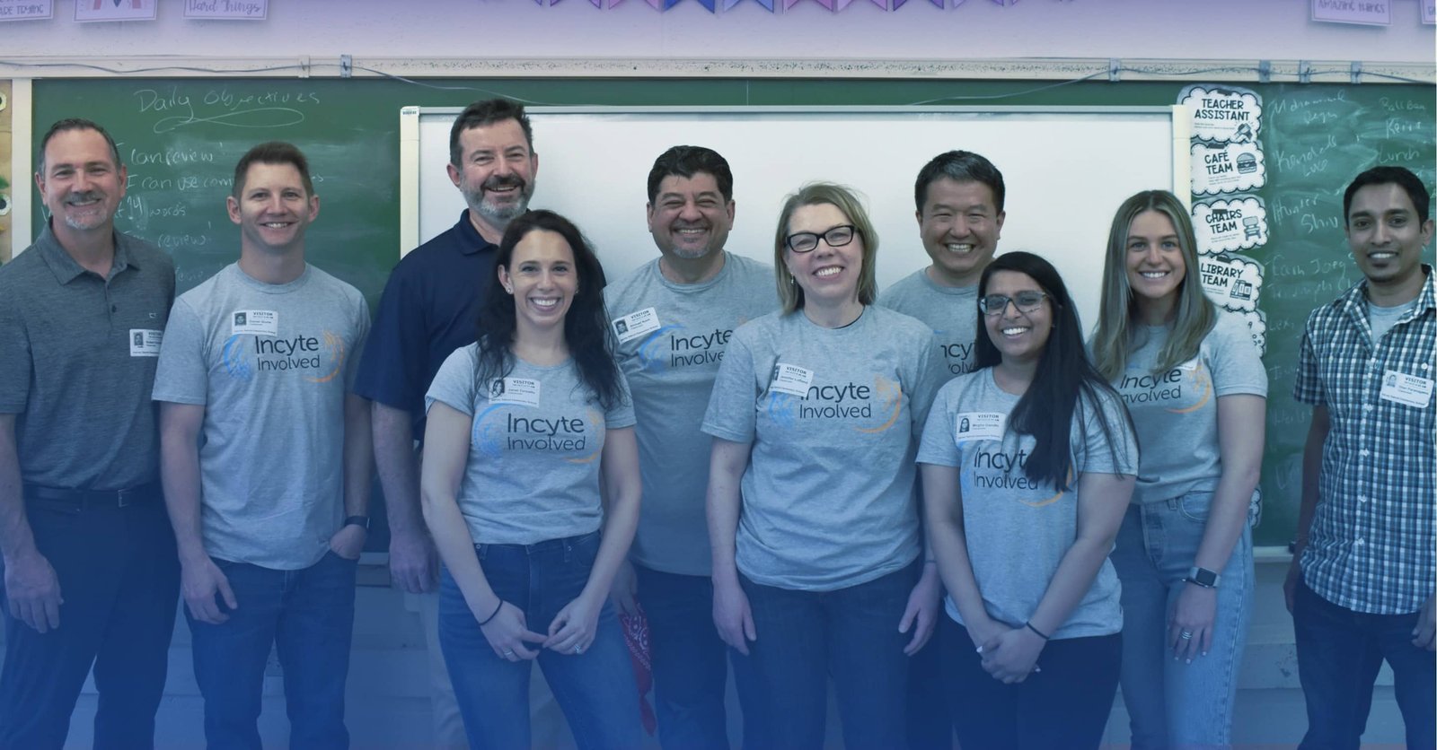 Large group of people standing in front of a chalkboard