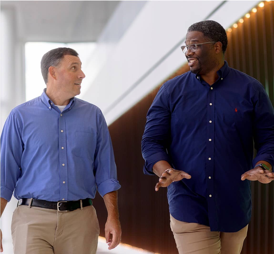 Two people walking down a hallway
